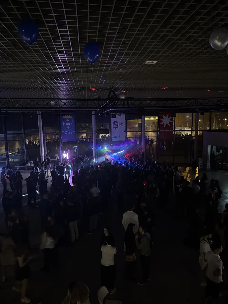 Soirée dansante sous une structure lumineuse, lyres et lasers, dans une grande salle